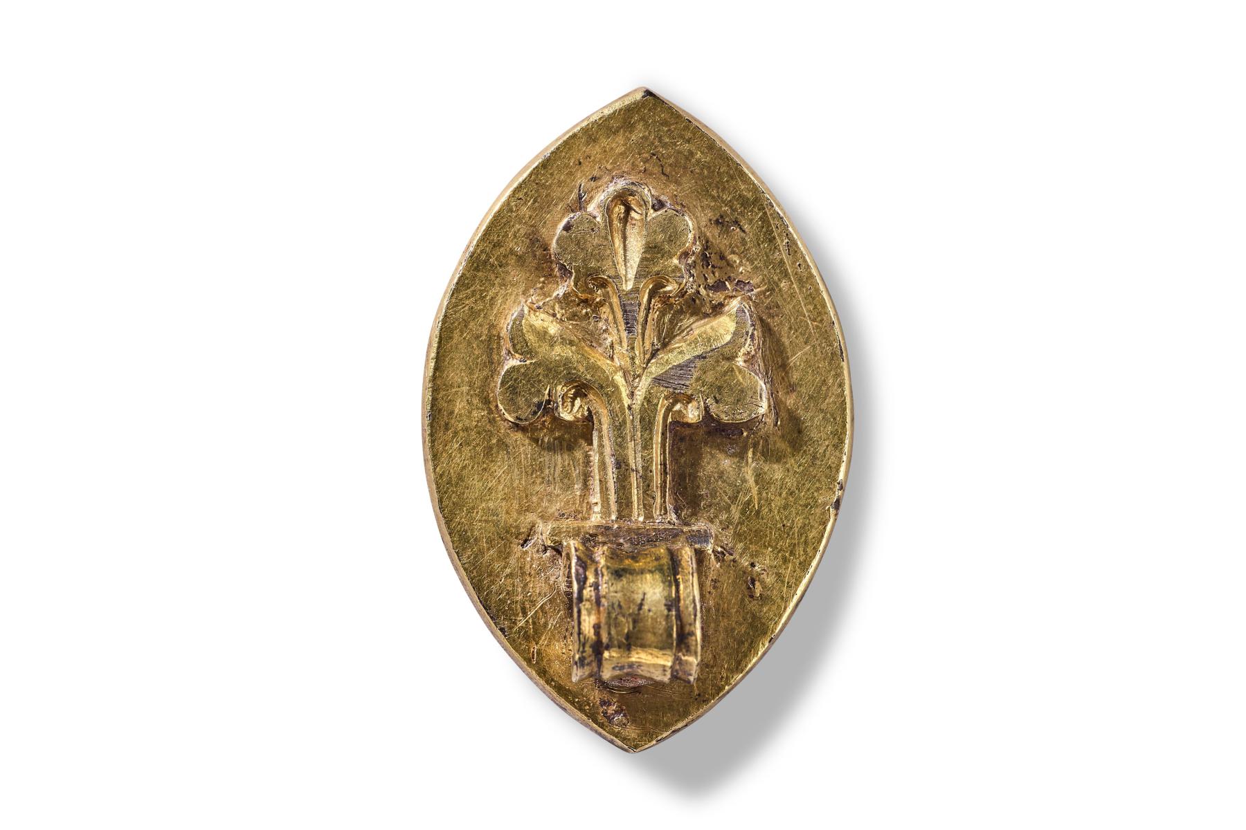 Rear of seal matrix with fleur de lis design and loop for hanging on a cord