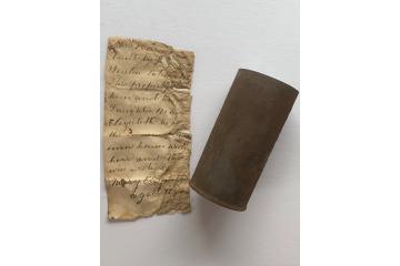 old tin can and written note on paper